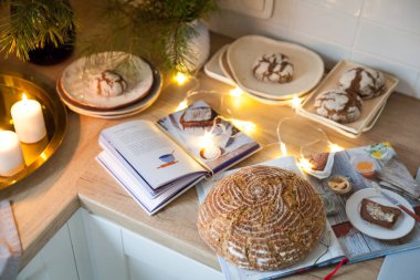 Süslü bir tatil mutfağında keten kumaş üzerinde lezzetli ekmek. Noel ağacının odaksız ışıkları. Tatil havası. Noel ve Mutlu Yıllar.