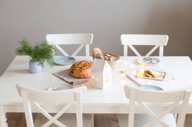Parlak bir oturma odasında ev yapımı ekmeği olan bir şenlik masası. Noel ve mutlu yıllar.
