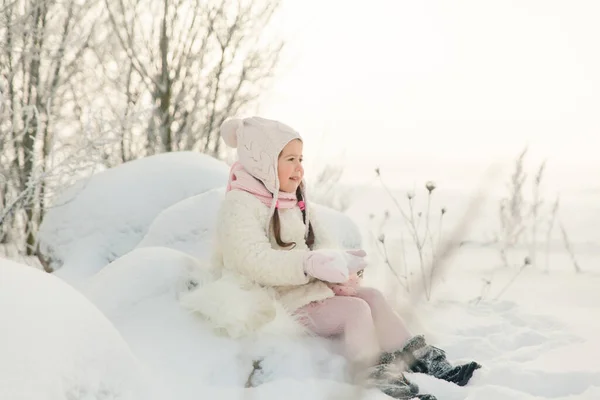 코트를 분홍색의 스카프를 소녀가 아름다운 눈덮인 숲에서 크리스마스 분위기 — 스톡 사진