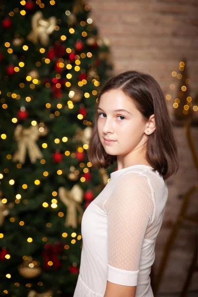 드레스를 머리의 소녀가 크리스마스 트리와 조명을 실내의 기대어 — 스톡 사진