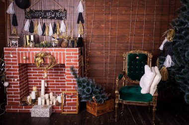 Şömineli ve yeşil sandalyeli rahat bir Noel salonu. Yeni yıl arifesi çok şık..