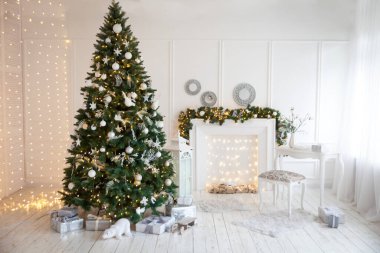 Açık renklerde, Noel ağacıyla süslenmiş, çelenklerle, oyuncaklarla ve şömineyle süslenmiş rahat bir Noel salonu. Yeni yıl arifesi çok şık..