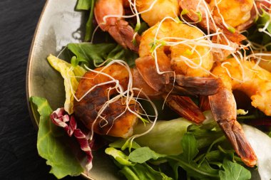 Taze salata üzerine tütsülenmiş karides ve Alfalfa filizi.