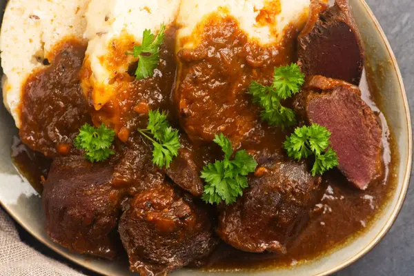 stock image Stewed goose stomach.  Traditional Polish meat on a dark background.