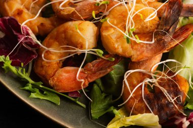 Taze salata üzerine tütsülenmiş karides ve Alfalfa filizi.