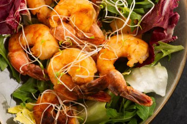 Taze salata üzerine tütsülenmiş karides ve Alfalfa filizi.