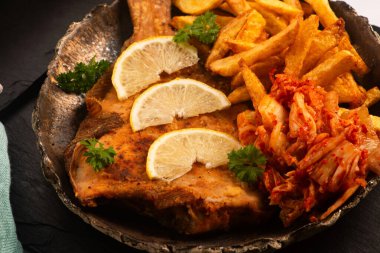 Patates kızartması ve kimchi ile haşlanmış dil balığı.