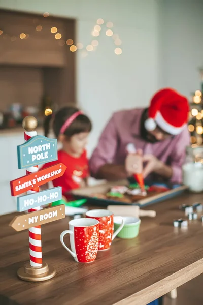 Mutfak Masasında Noel Süslemesi Arka Planda Zencefilli Kurabiye Pişiren Bir — Stok fotoğraf
