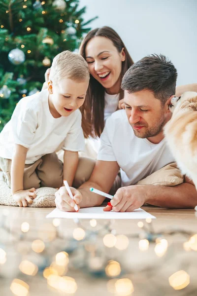 어머니와 아버지와 산타클로스에게 편지를 크리스마스 근처에서 선물을 보내는 가족들의 — 스톡 사진