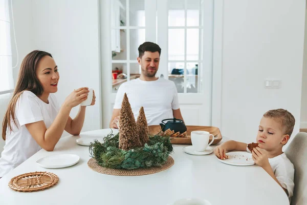 圣诞节早上 一家人坐在桌旁 爸爸和他们的小儿子喝茶 吃蛋糕当圣诞早餐 — 图库照片
