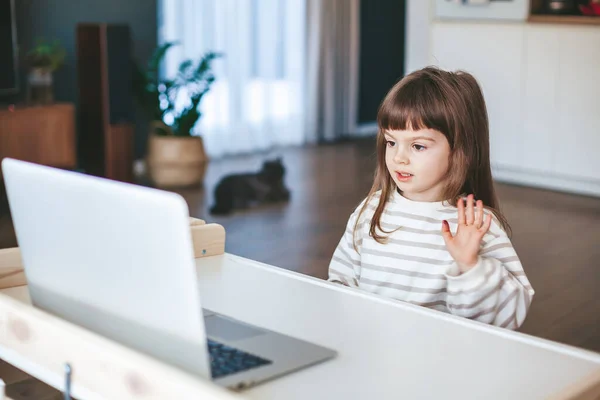 可爱的小女孩还在网上做手指体操 看着笔记本电脑的屏幕 — 图库照片