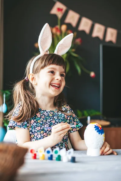 소녀가 테이블에 그림으로 부활절 달걀을 그리고 부활절 기념행사 — 스톡 사진