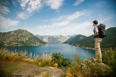 Bir uçurumun kenarında duran turist, Karadağ 'ın Kotor Körfezi manzarasının tadını çıkarıyor