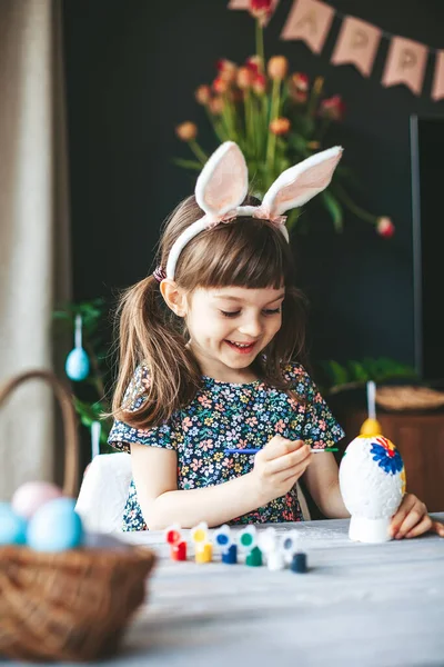 소녀가 테이블에 그림으로 부활절 달걀을 그리는 부활절 기념행사 — 스톡 사진
