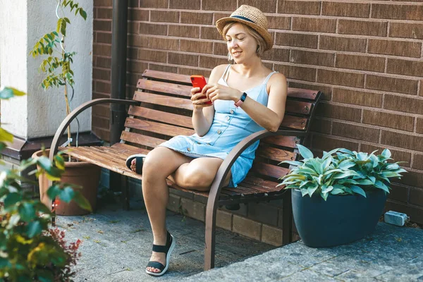 Saman Içindeki Kadın Bahçede Bir Bankta Otururken Akıllı Telefon Kullanıyor — Stok fotoğraf