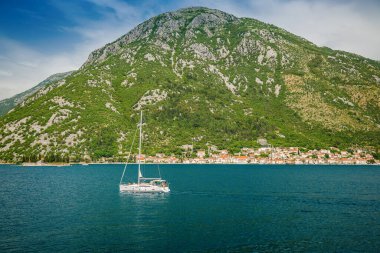 Karadağ 'ın güneşli ve güzel bir gününde ünlü Kotor Körfezi' nde tarihi Perast kasabasında yelken açan yat.