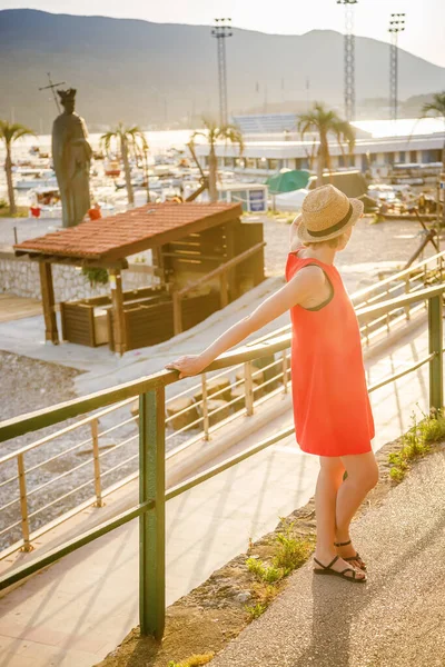 黑山新海尔采市海滨站着一位戴着草帽 身穿红色连衣裙的妇女的背影 — 图库照片