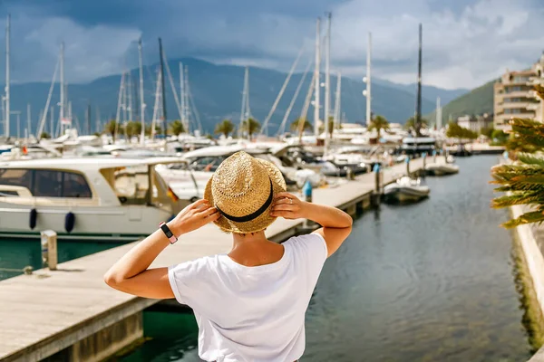 黑山科托尔湾Tivat港一名戴着草帽的旅游妇女看着游艇的后视镜 — 图库照片