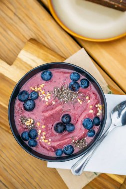 Çiğ meyve suyu kasesi, taze yaban mersini ve chia çekirdeği. Sağlıklı vejetaryen gıda konsepti.