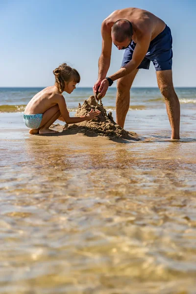 暑假时 小女孩和她的父亲在海滩上玩耍 — 图库照片