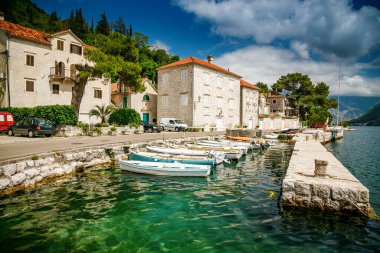 Karadağ 'ın Boka Kotor körfezindeki Perast limanında küçük tekneler demirlemiş durumda