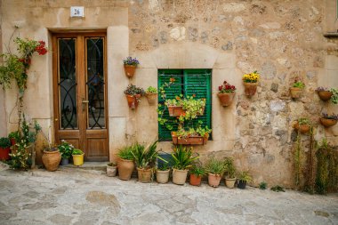 Valldemossa, Mallorca, İspanya 'nın büyüleyici köyünde çiçeklerle dolu bir evin tipik girişi.
