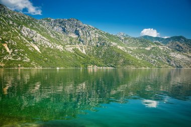 Karadağ 'da güneşli bir günde şeffaf mavi denizli güzel bir Kotor Körfezi manzarası