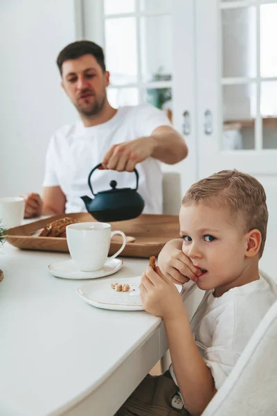Ojciec Jego Synek Białych Ciuchach Piją Herbatę Jedzą Ciasto Śniadanie Zdjęcia Stockowe bez tantiem