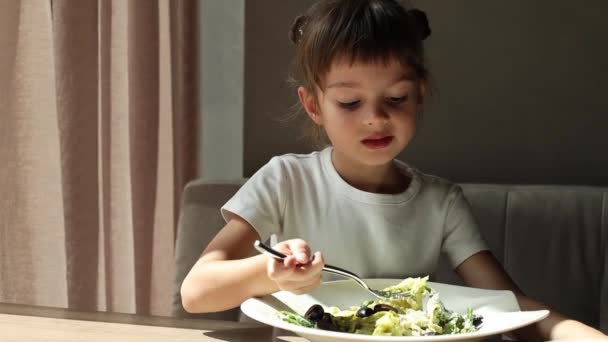 一个可爱的女孩5 6岁有一个意大利面与奶酪意大利面 免版税图库视频