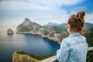 Mallorca 'daki Mirador de El Colomer' den nefes kesici bir manzaraya bakan küçük bir kız korku ve sükunet hissi uyandırıyor.