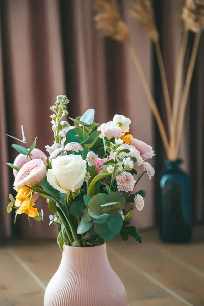 バックドロップのエレガントなピンクのカーテンを補完し 香りの花束を保持するテクスチャされたピンクの花瓶を閉じます ロイヤリティフリーのストック画像