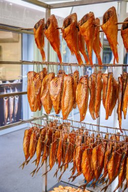 Taze tütsülenmiş balık canlı bir yerel markette metal bir rafta sergileniyor.