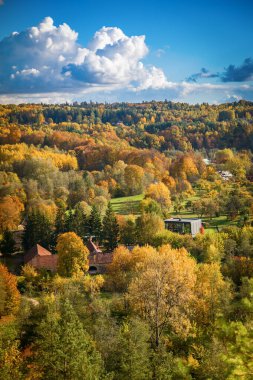 Puckoriu atodanga in Pavilniai Regional Park, Vilnius, Lithuania, during autumn, features a scenic view of colorful foliage in green, yellow, and orange clipart