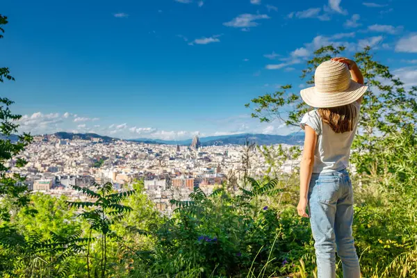 Barselona 'nın manzarası, saman şapkalı küçük bir kızın manzaranın tadını çıkarmasıyla gözler önüne seriliyor.