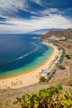Las Teresitas sahilinin havadan görünüşü, dinlenen insanlar, sakin suların ve Tenerife 'deki manzaralı dağ manzarasının tadını çıkarıyorlar.