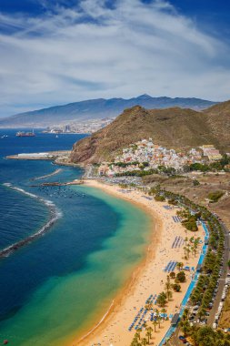 Las Teresitas 'ta dinlendirici bir hava sahnesi, dinlenme yerleri, berrak sular ve dağ manzarası, Tenerife' nin plaj cazibesini gözler önüne seriyor.