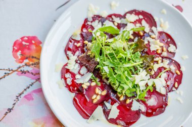İnce dilimlenmiş roka, çam fıstığı ve parmesan soslu pancar carpaccio.