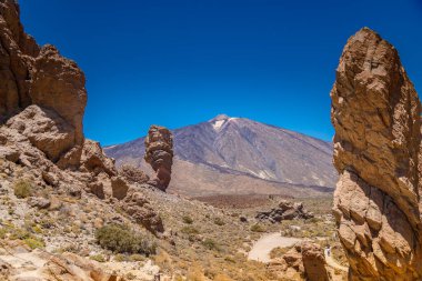 Zorlu ve gerçeküstü Roques de Garcia kaya oluşumları Teide Ulusal Parkı 'nın kurak manzarasından yükseliyor ve hayranlık uyandırıcı bir sahne yaratıyor.