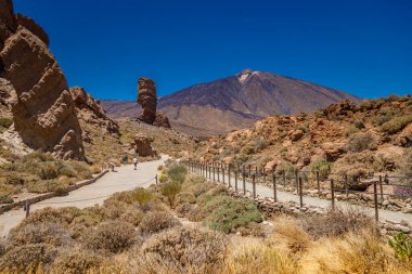 Tenerife 'deki Roques de Garcia' nın doğal harikalarına karşı duran Teide Dağı 'nın muhteşem manzarasının tadını çıkaran bir turist kadın.