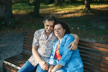 Yaşlı çiftlere sarılıp, yeşil bir parktaki ahşap bankta güzel vakit geçirmek.
