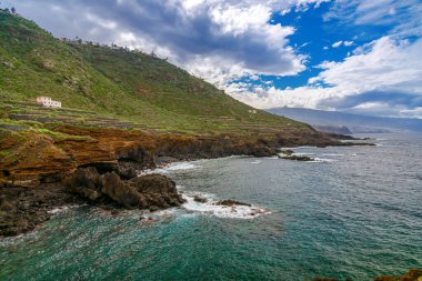 Engebeli kayalıklar El Sauzal, Tenerife kıyısında Atlantik Okyanusu 'yla buluşuyor. Kayalık kıyı şeridinin üzerindeki yeşil tepeler ve teraslı manzaralar suyla çarpıcı bir zıtlık yaratır.