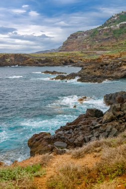 El Sauzal, Tenerife 'nin Rocky kıyı manzarası, dramatik uçurumlar ve engebeli bir okyanus buluşması. Bulutlu gökyüzü bu doğal işaretin manzaralı güzelliğine ekleniyor.