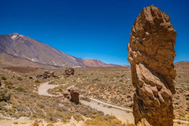Tenerife 'deki açık mavi gökyüzünün altında Teide Dağı' nın altında Roques De Garcia kaya oluşumunun nefes kesici görüntüsü. Engebeli arazisiyle büyüleyici volkanik manzara
