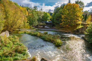 Belmontas sonbahar şelalesi altın ağaçlarla çevrili eski değirmen binası ve akan nehir turizm için pitoresk Litvanya mirası manzarası oluşturuyor