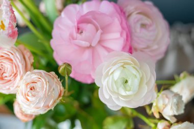 Güzel karışık ranunculus buketi pembe beyaz ve şeftali çiçekleri düğün süslemeleri ve romantik kutlamalar için zarif bahar düzenlemeleri yapıyor.