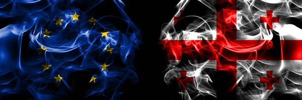 Flags of EU, European Union vs Georgia, Georgian. Smoke flag placed side by side on black background.