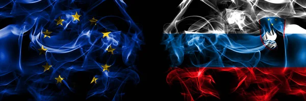 Flags of EU, European Union vs Slovenia, Slovenian. Smoke flag placed side by side on black background.