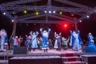 Noel Baba sahnedeki Yeni Yıl gösterisinde şehir sokaklarında.