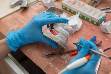 Takma dişlerin elle üretimi.