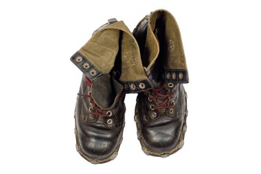 Tabanda metal çivili deri çizmeler, kahverengi bağcıklar ve kumaş kelepçeler..